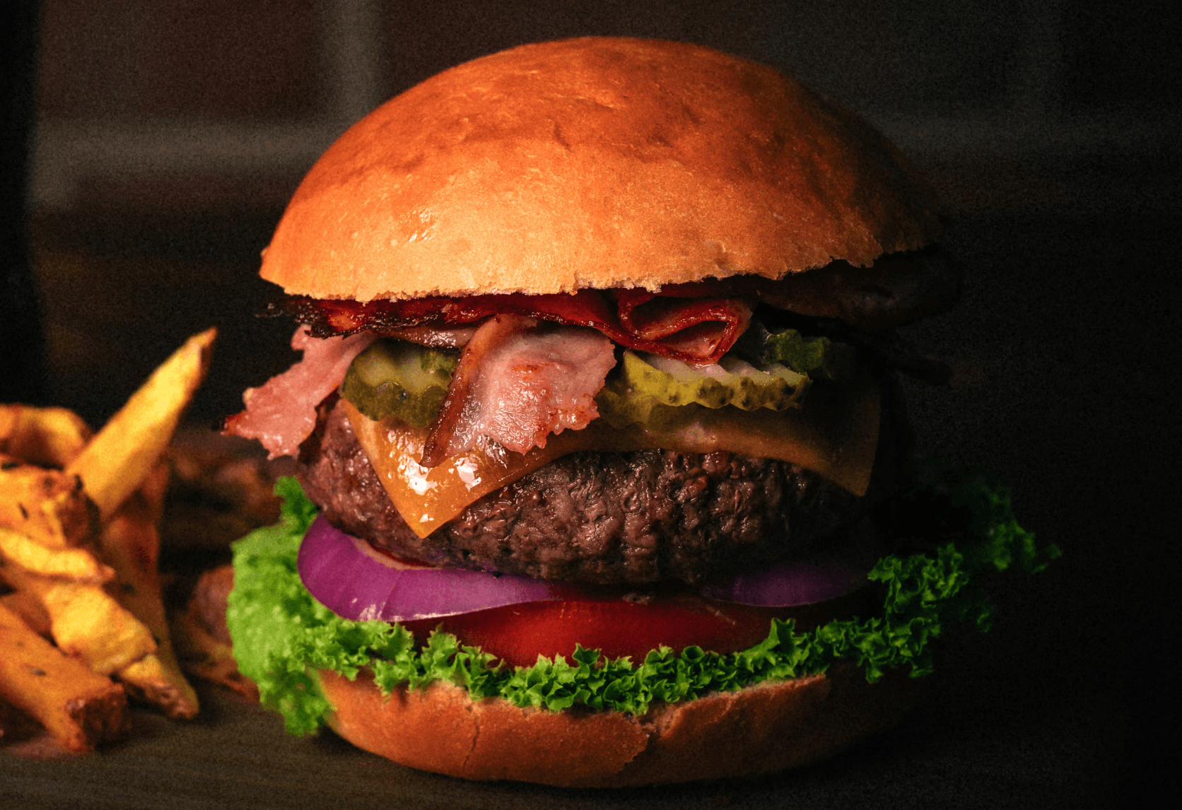 David B. Vacuno mayor, brotes de lechuga batavia, tomate fresco en rodajas, aros de cebolla morada, pepinillo, bacon, cheddar gratinado & pan brioche.