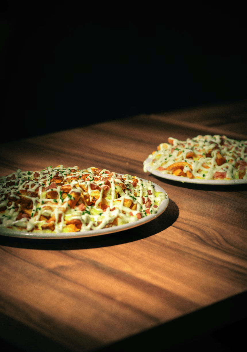 PapiGrill. Patatas naturales cortadas a diario, con mozzarella y gouda fundidos, nuestra salsa especial ranchera, bacon crujiente y topping de cebollino.